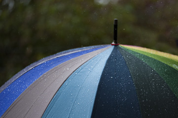  Close-up  umbrella in rainbow colors in rainy autumn day, blur focus