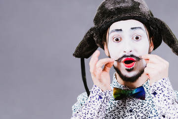 cheerful mime posing and grimacing in the studio