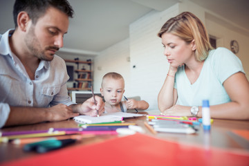 Obraz premium Young parent and son drawing in the living room.