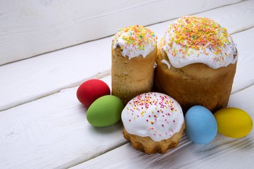 National Russian Easter cake and colored eggs on white wooden background
