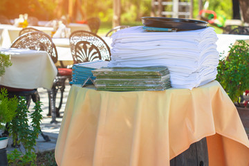 Tutu white tablecloth is on the table. A stack of menus in the area, staff café.
