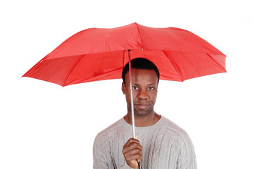 Black man standing and holding a red umbrella