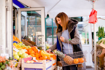Smiling woman buying fruits
