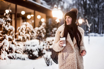 Woman drink coffee in winter evening.