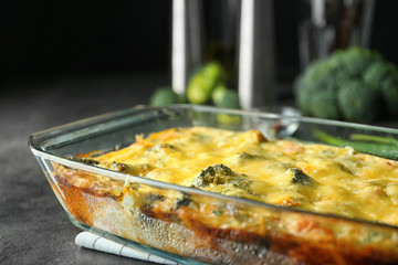 Glass baking dish with tasty broccoli casserole on table. Fresh from oven