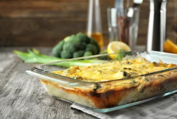 Wall murals meal dishes Glass baking dish with tasty broccoli casserole on table. Fresh from oven