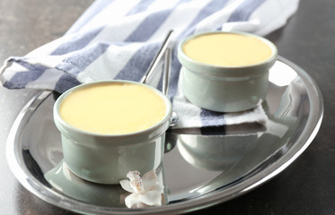 Ramekins with tasty vanilla pudding on metal tray