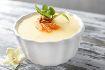 Ramekin with tasty vanilla pudding on table