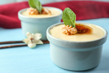 Ramekins with tasty vanilla pudding on table