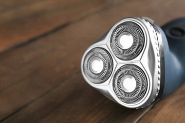 Electric shaver for man on wooden background