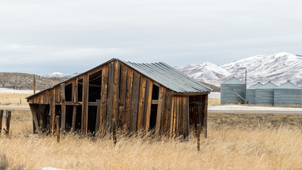 Old wooden farmers shed on a rural road in winter