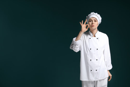 Female chef in uniform on dark background