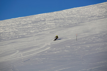 Skier skiing downhill in mountains