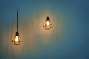 Elegant lamps hanging on color background