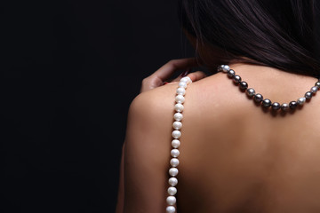 Portrait of beautiful nude long straight black hair woman with pearl necklace