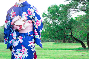 Woman wearing Kimono traditional Japan walking at public park.