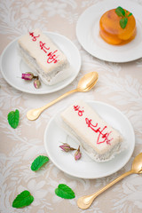 A fresh piece of coconut cream cake on a white plate with a whipped cream and peach jelly. White background. Top view