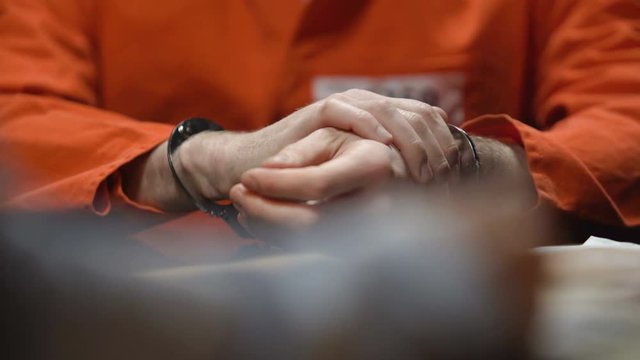 Inmate warms up wrists in handcuffs, gives evidence, detective writing testimony