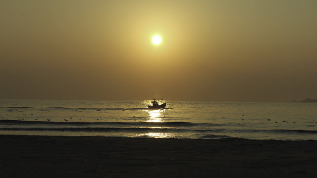 Fishing boat departing at sunrise