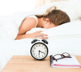 A young woman putting her alarm clock off in the morning