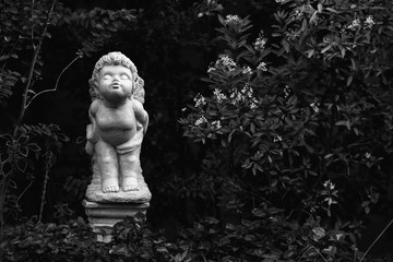 white Figurine of an angel stand and kiss in garden home on the day