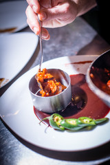 Man's hand holding spoon and red sauce