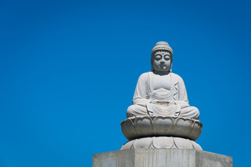 Fototapeta na wymiar Stone Budda statue in front of a clear blue sky in Australia