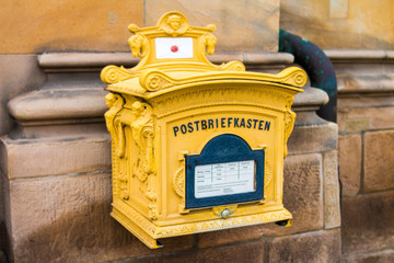alter verzierter Postkasten in gelb 