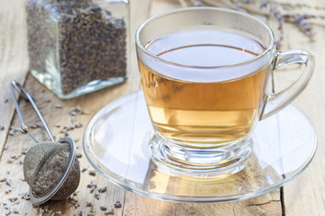 Healthy herbal lavender tea in glass cup with lavender flowers on background, horizontal