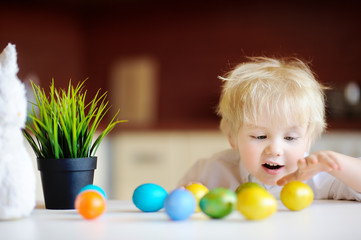 Fototapeta na wymiar Cute toddler child hunting for easter egg on Easter day