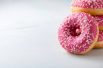 Donut. Sweet icing sugar food. Dessert colorful snack.Treat from delicious pastry breakfast. Bakery cake. Doughnut with frosting. Baked unhealthy round on a blue background. with copy space