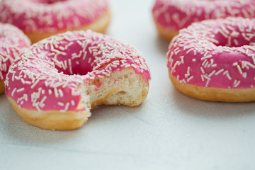 Bitten donut. Sweet icing sugar food. Dessert colorful snack. Glazed sprinkles. Treat from delicious pastry breakfast. Bakery cake. Doughnut with frosting. Baked unhealthy round