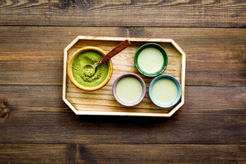 Make matcha tea. Matcha tea in small cups ready to drink on dark wooden background top view copy space