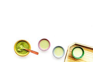 Make matcha tea. Matcha tea in small cups ready to drink on white background top view copy space