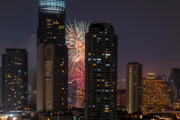 Closeup scene of multicolor fireworks with bangkok cityscape river view at night time, Celebration and building concept