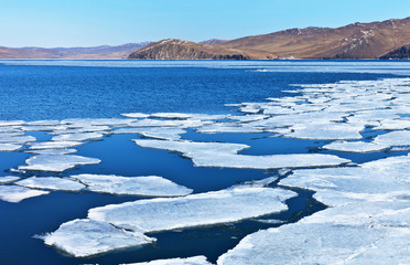 Baikal Lake in April. A fresh spring breeze chases the white ice floes to the Olkhon Gates Strait (Olhonskie Vorota)