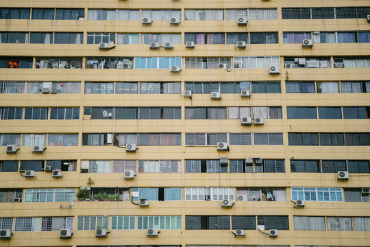 A Portrait Of An Apartment Building In Singapore. It Is Yellow In Color And Air Conditioning Is Also Available For Some Residents.
