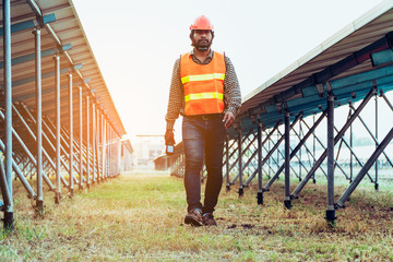 solar power plant to innovation of green energy; engineer or electrician working on checking and maintenance equipment at solar power plant