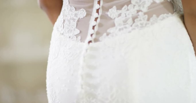 4K Back view of bride trying on her gown in wedding dress store, close up on the detailing of the gown