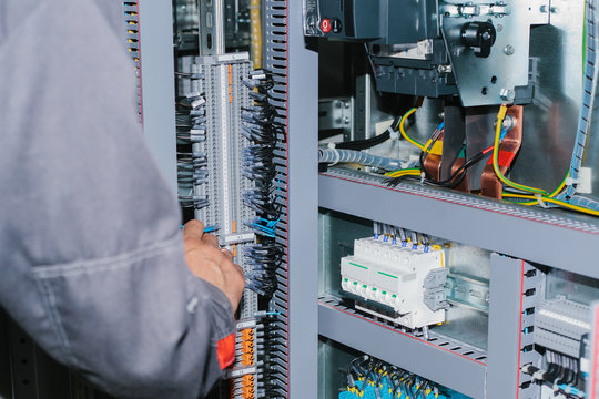 Electrician specialist checking low-voltage cabinet equipment