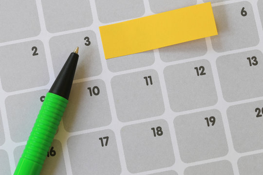 Green pen points to a three number of calendar and have blank yellow note paper.