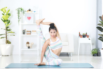 Beautiful asian sports woman performs the exercises at home .Yoga