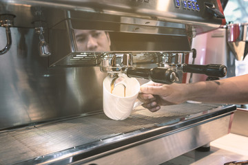 Barista made drink by coffee machine with vintage tone.