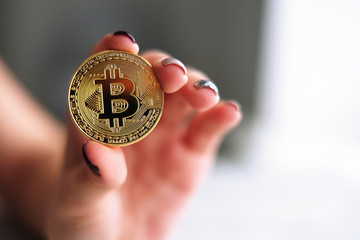 Fototapeta na wymiar Hand holding golden Bitcoin virtual money.