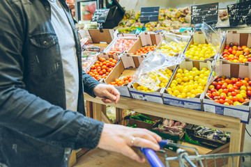 man seek vegetables in supermarket