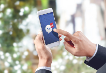 businessman hand touch social media icon on mobile screen