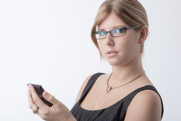 Fototapeta premium Junge Frau mit Brille hält einen Taschenrechner