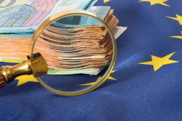 Flagge der Europäischen Union EU, eine Lupe und Euro Geldscheine