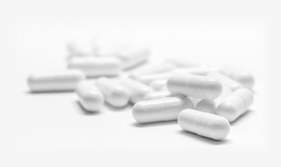 White medicine capsules on white background