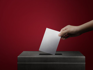 Hand holding ballot paper for election vote concept background.